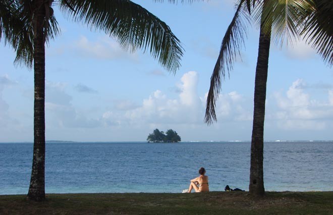 Sunbather and typical motu or tiny island © BW Media